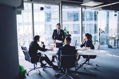 Gruppe von Geschäftsleuten, die als Strategieteam in einem modernen Bürogebäude diskutieren