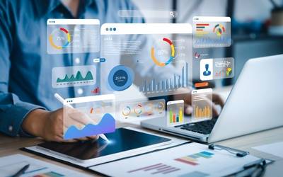 Ein Analyst arbeitet am PC, eingeblendet werden zahlreiche Balken, Kurven- und Tortendiagramme 