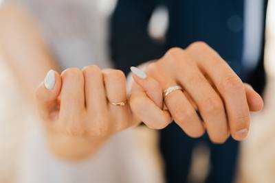 Zwei Frischverheiratete halten sich an den kleinen Fingern, CloseUp
